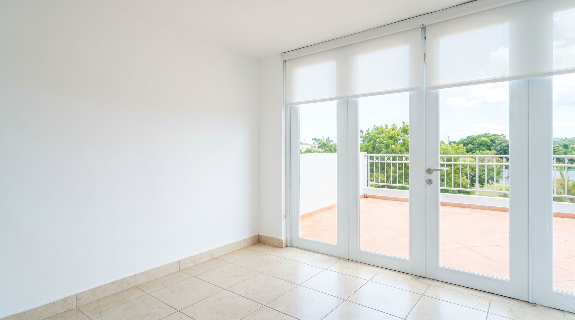 Cuarto con puertas de cristal de piso a techo hacia la terraza